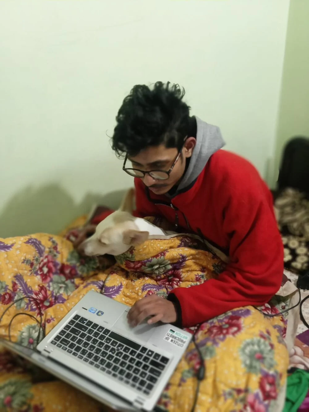 Aman as a teenager working on a laptop